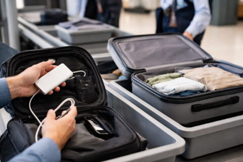 Powerbank im Handgepäck am Flughafen-Sicherheitscheck, Koffer im Hintergrund